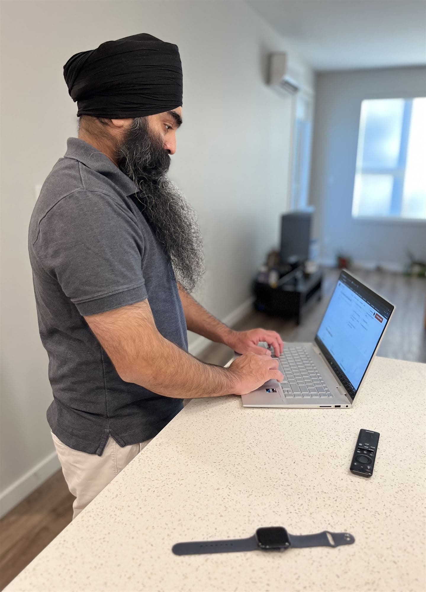 Mani Fateh setting up a laptop at a kitchen counter